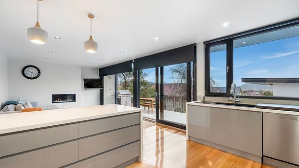 A modern kitchen with a large island, built-in appliances, and a view of the outdoors.