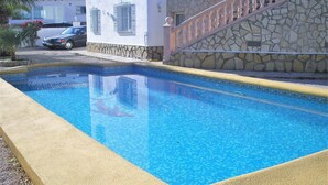 Une piscine avec un mur en pierre et un bord jaune.