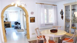 Un coin repas comprenant une table ronde, quatre chaises et un buffet aux portes vitrées.