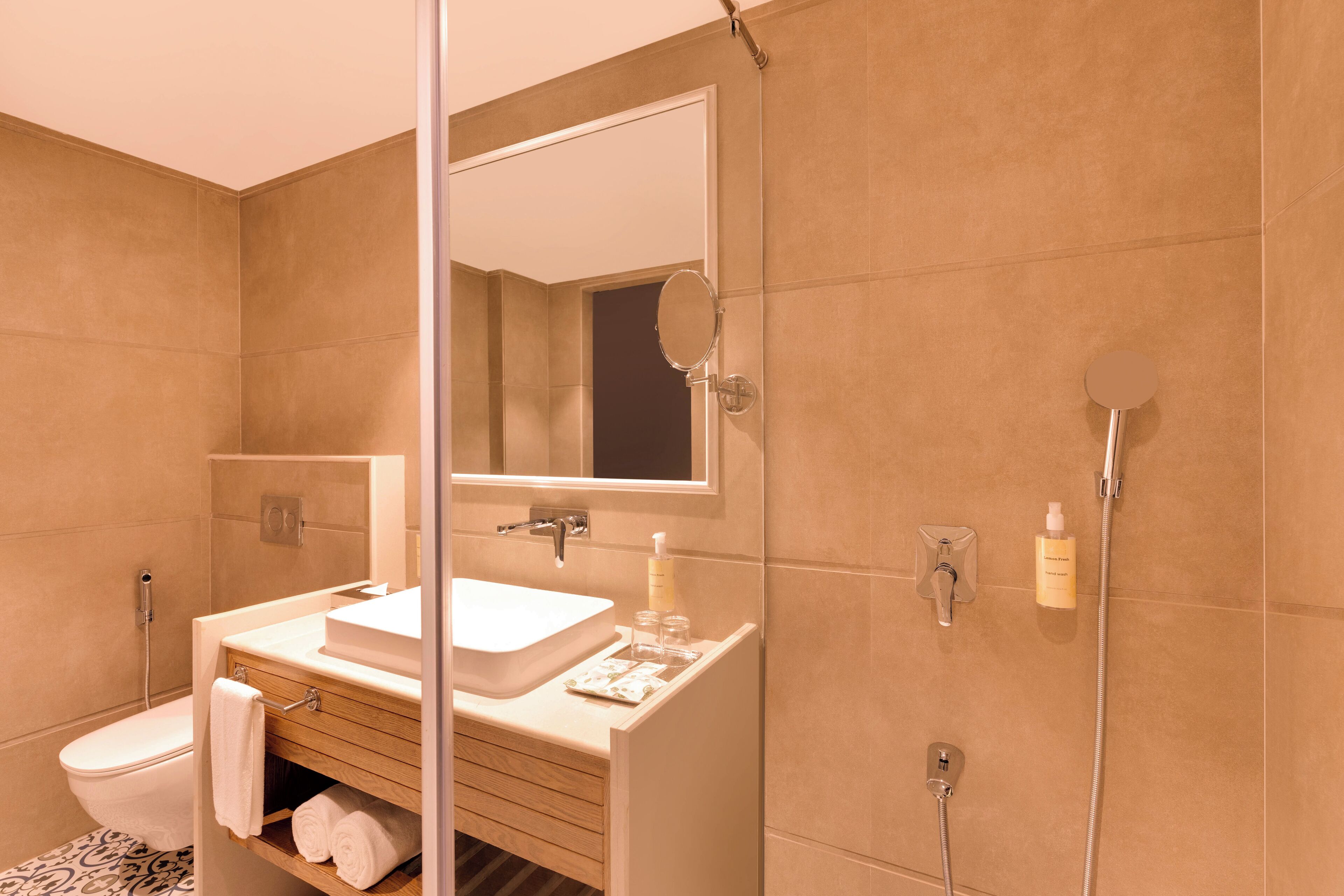 Un bany modern amb un lavabo, mirall i plat de dutxa.