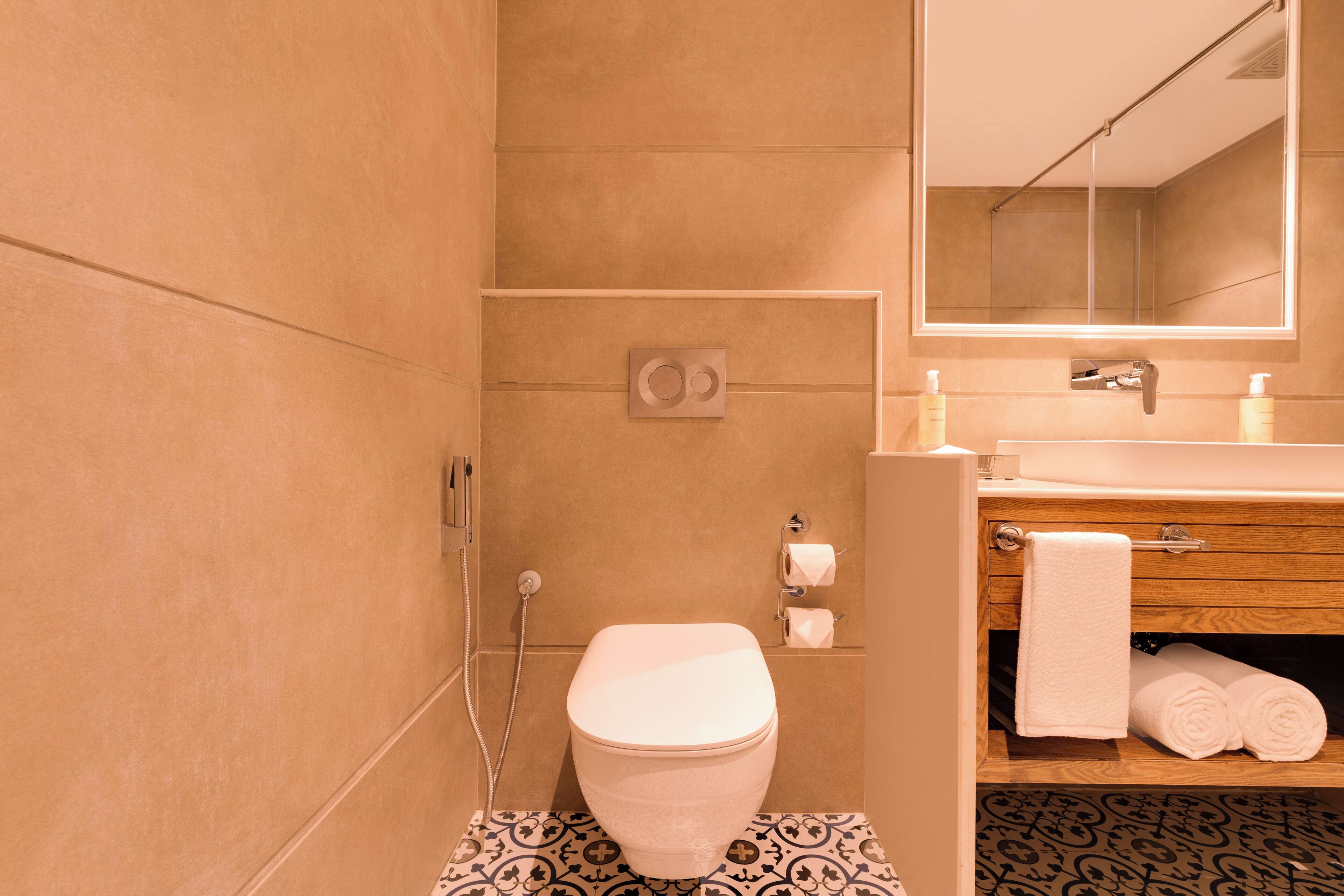 A modern bathroom with a toilet, sink, and mirror.