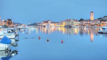 A waterfront town with historic buildings, a prominent tower, and calm water reflecting the structures.