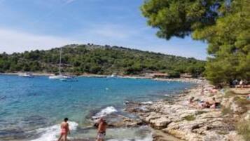 A coastal scene with rocky terrain and clear blue waters.