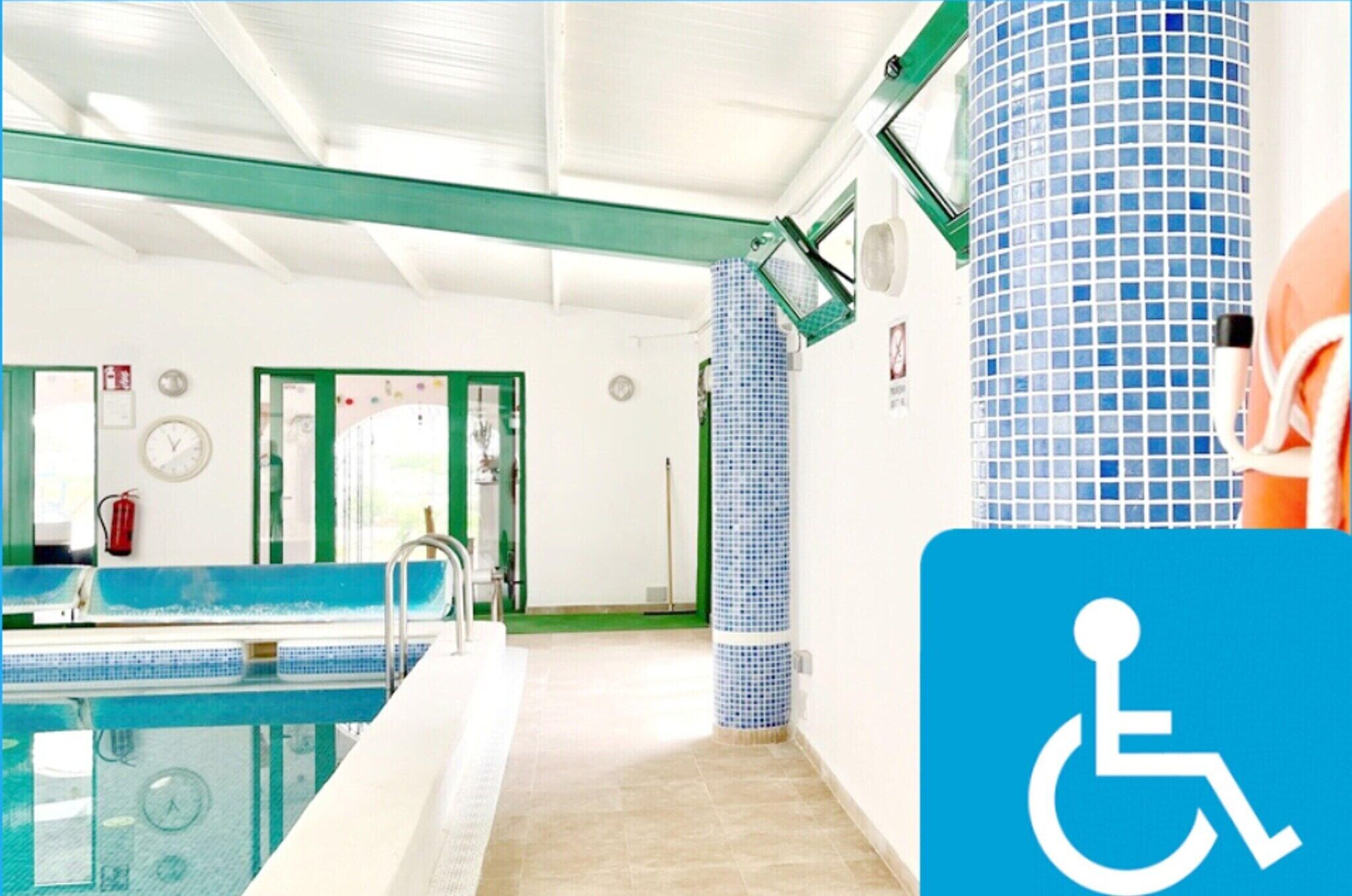 En inomhuspool med en blå kakelbeklädd vägg, ett grönt och vitt tak samt ett blått och vitt kakelbeklätt golv.