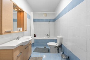 Bañera con ducha, toallas, jabón, shampoo