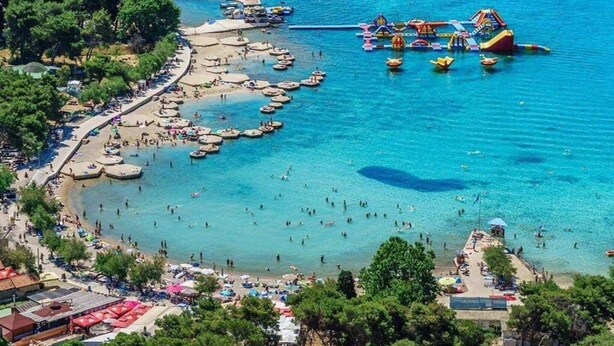 Een kustgebied met een strand, boten en een waterpark.
