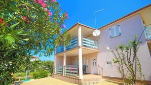 A two-story building with a balcony, a satellite dish, and a door marked with the number 15. - Apartment in Tribunj near Tribunj Beach (Tribunj)