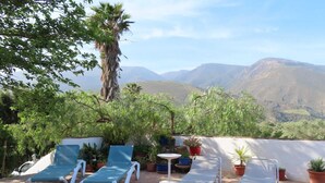 A terrace with lounge chairs and potted plants, overlooking a mountainous landscape. - Holiday Home in Orgiva with Mountain Views (Orgiva)