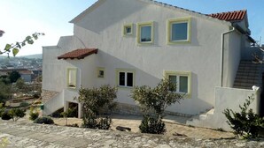 Um edifício de dois andares com fachada branca e molduras de janela amarelas.