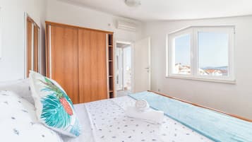 Una camera da letto con un letto, un armadio, una finestra vista e un condizionatore.