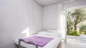 A bedroom with a bed, white walls, a window, and a view of greenery outside. - Apartment in Šibenik near Adriatic Beaches (Šibenik-Brodarica)