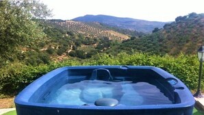 A hot tub with a view of a hilly landscape. - Country House in Andalusia with Pool (Andalucía)