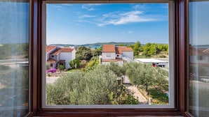 Vista desde una ventana con vista a una zona residencial con casas, vegetación y cielo despejado.