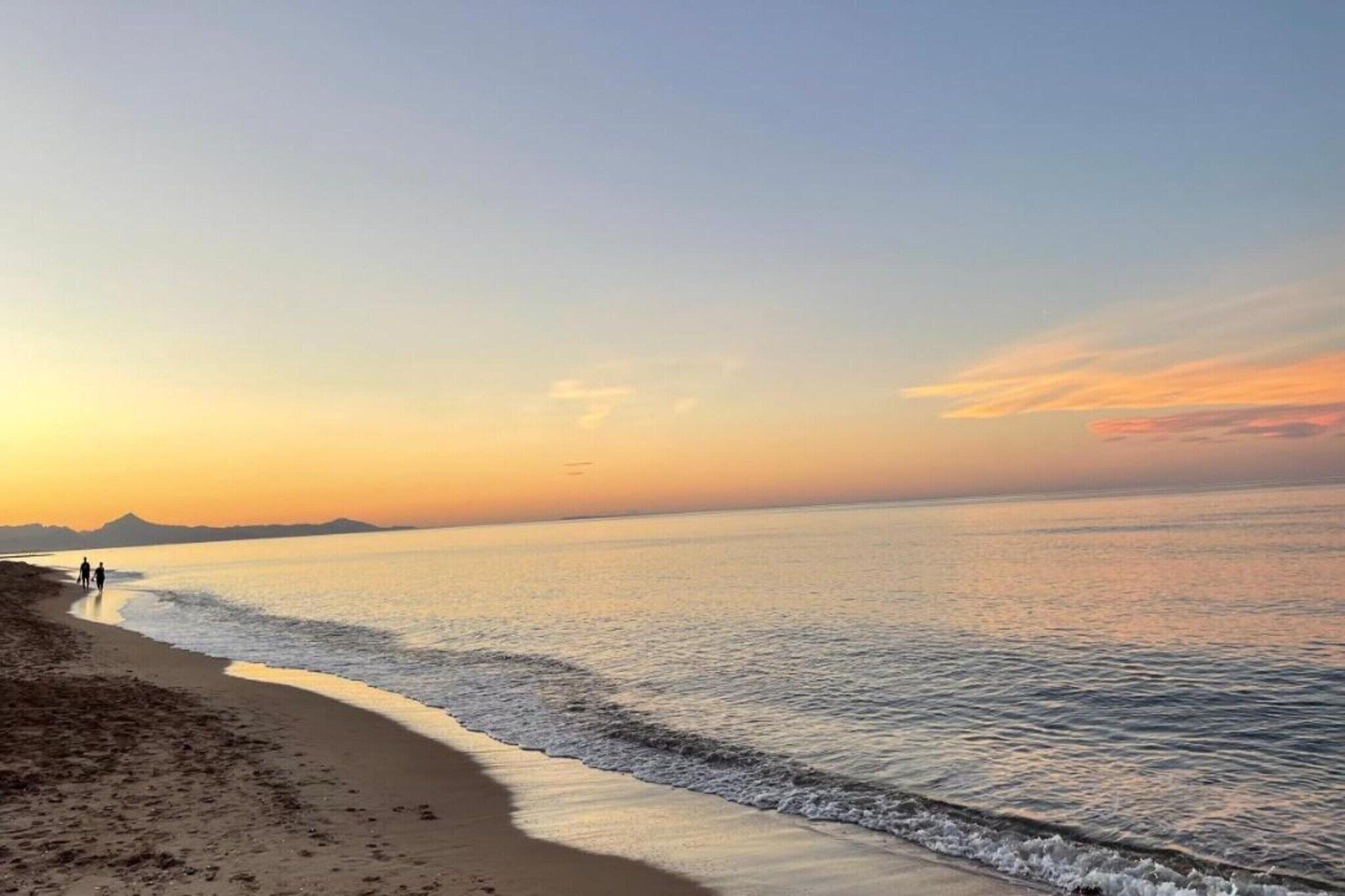 A beach scene with a clear sky and calm sea.