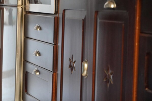 Ein Detailaufnahme eines Holzschranks mit Schubladen und sternförmigen Griffen.