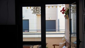 A balcony with wicker furniture and a hanging light fixture.
