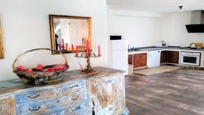 A kitchen with a white refrigerator, microwave, and oven. There's a wooden cabinet and a white countertop.