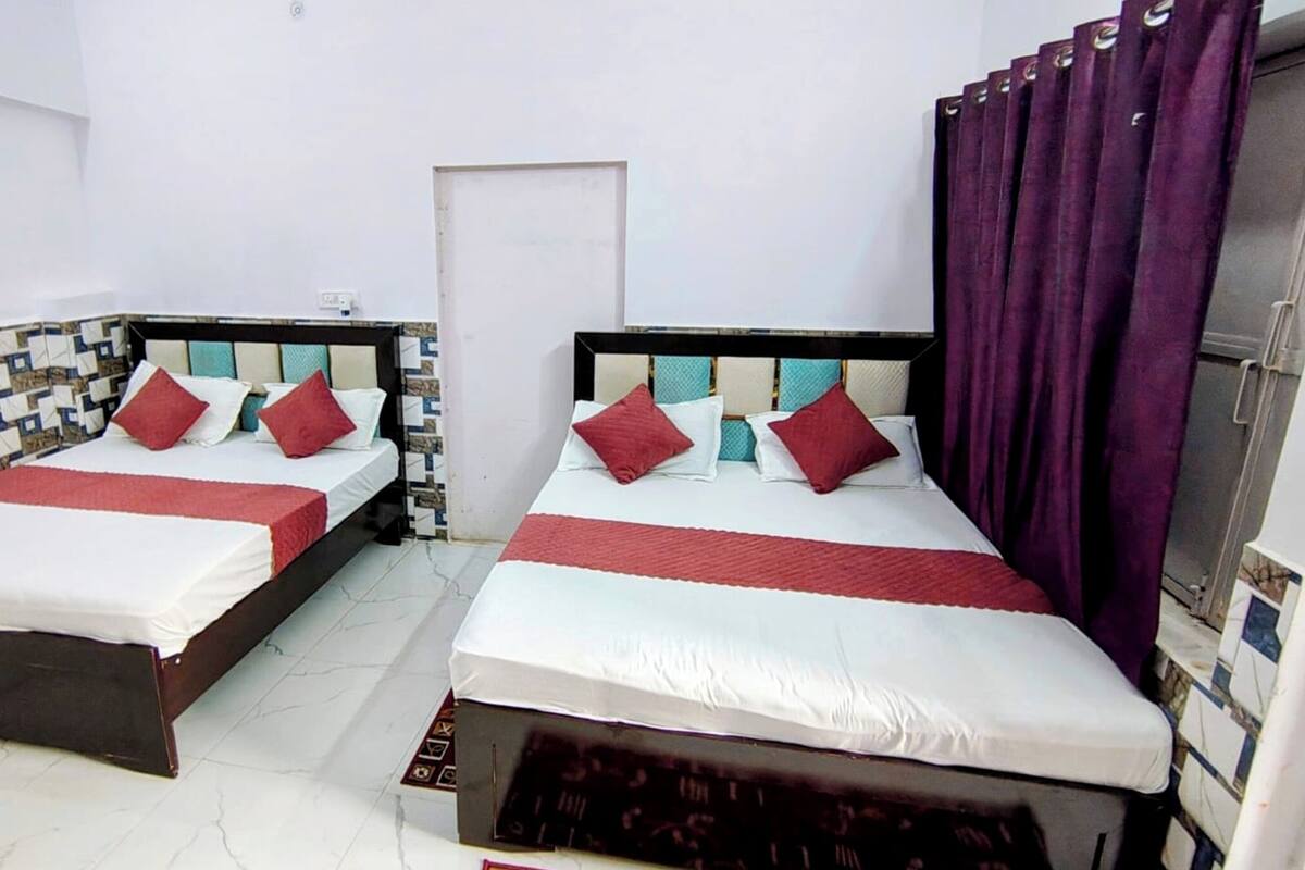 Two single beds with headboards, white bedding, and red pillows.