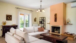 A living room with a sofa, coffee table, fireplace, and a bookshelf.