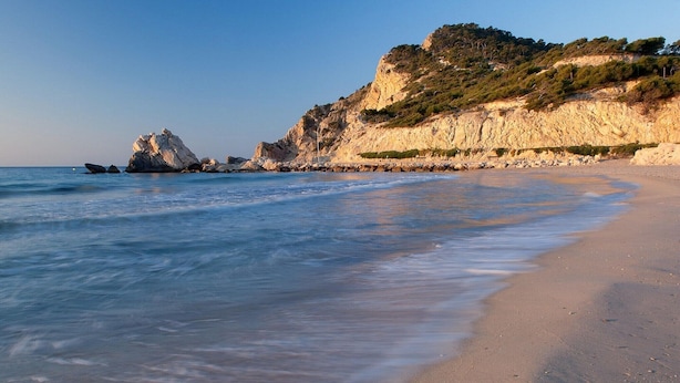 A beach with clear blue waters, rocky cliffs, and a sandy shore. - Bungalow Orihuela Costa Sunset and Pool (Relleu)