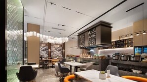 A modern restaurant interior with a bar area, seating arrangements, and a kitchen visible in the background. - Linfen Wanda Yuehua Hotel (Linfen)