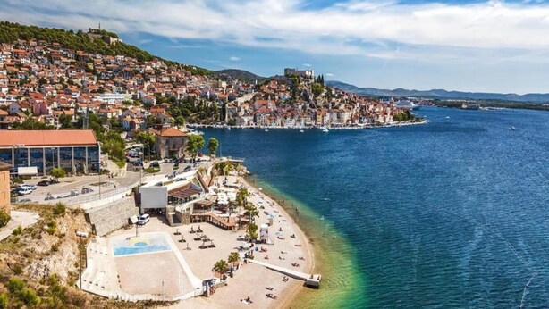 A coastal town with a beach, a pier, and a hilltop castle. - Apartment Šibenik near Beach Gaj (Šibenik-Brodarica)