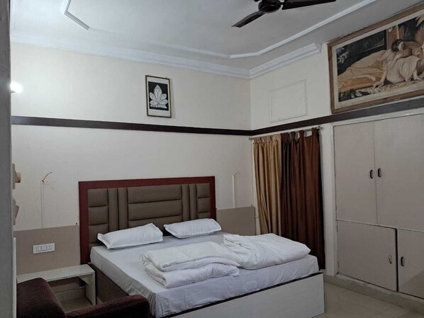 Un dormitorio con cama, ventilador de techo, un cuadro y un armario.