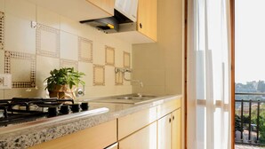 A kitchen with a granite countertop, wooden cabinets, a stainless steel sink, and a gas stove. - Apartment in Pietra Ligure (Pietra Ligure)