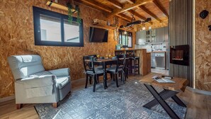 A cozy wooden interior with a dining area, a sofa, and a kitchen with a built-in grill. - Holiday home in Córdoba with Swimming pool (Zambra)