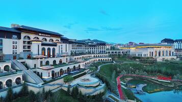 A large hotel complex with multiple buildings, a central courtyard, and a surrounding water body.