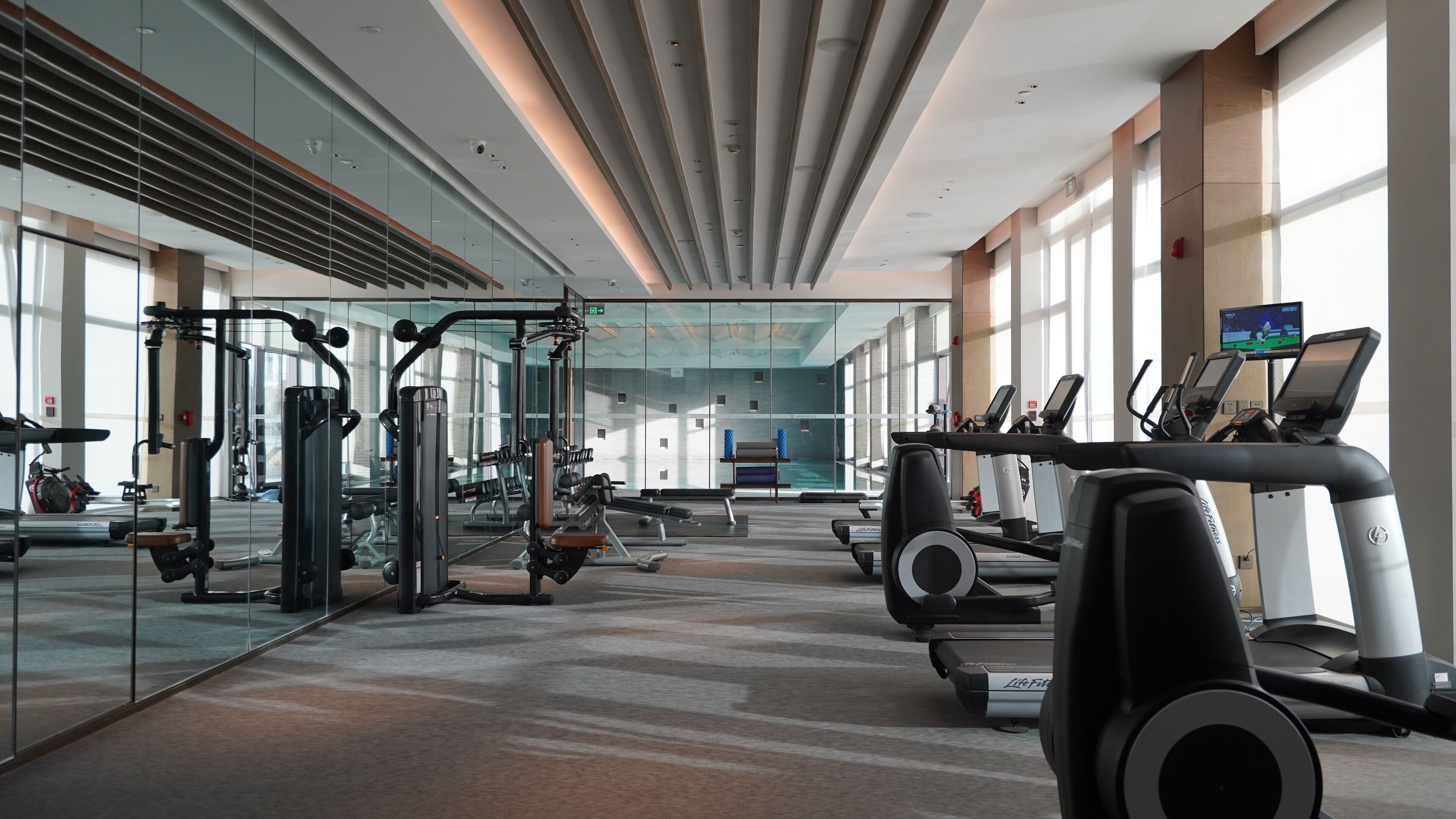 A modern gym with treadmills, weight machines, and exercise equipment.