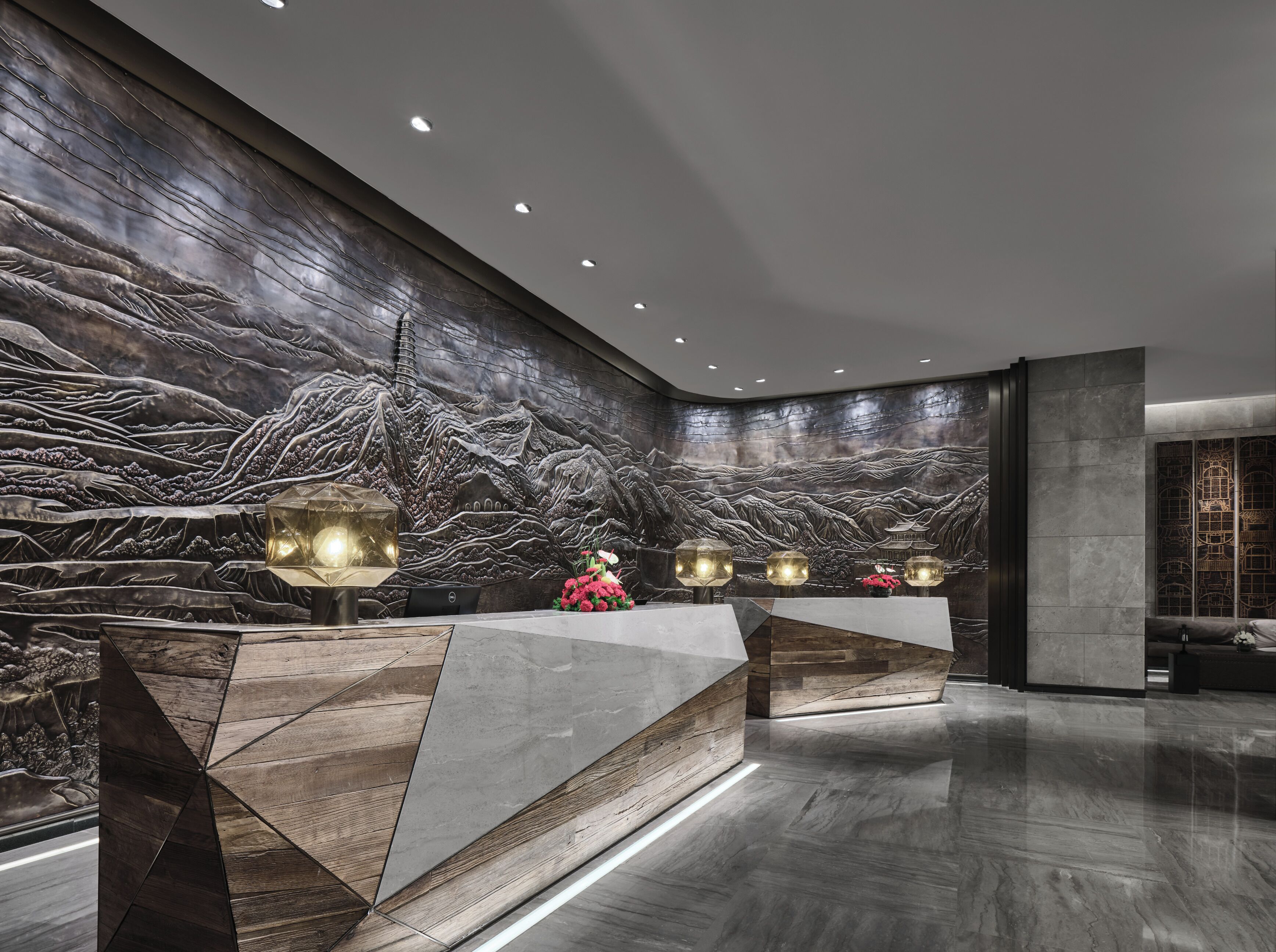 A modern reception area with a large wall mural, a reception desk, and a seating area.