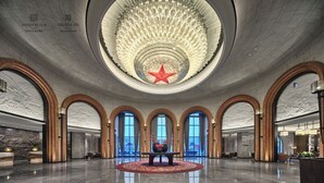 A spacious lobby with a central red star decoration, large arched windows, and a polished marble floor. - WANDA REALM Yan'an (Yan'an)