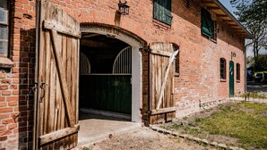 A brick building with two large wooden doors and a small arched entrance.