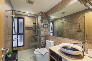 Enjoy a refreshing shower in the bathroom with a clear glass enclosure, contemporary showerhead, and a large round sink.