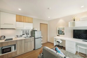 Cozy living space with a kitchenette, dining area, and desk, perfect for relaxing and staying productive.