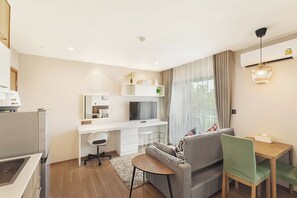 Relax in this stylish living space with a comfortable sofa, flat-screen TV, and desk.