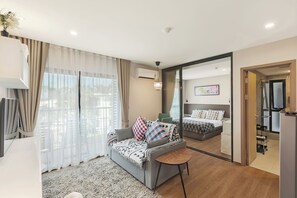 Relax in this stylish living room with a sofa, coffee table, and large sliding door leading to a balcony.