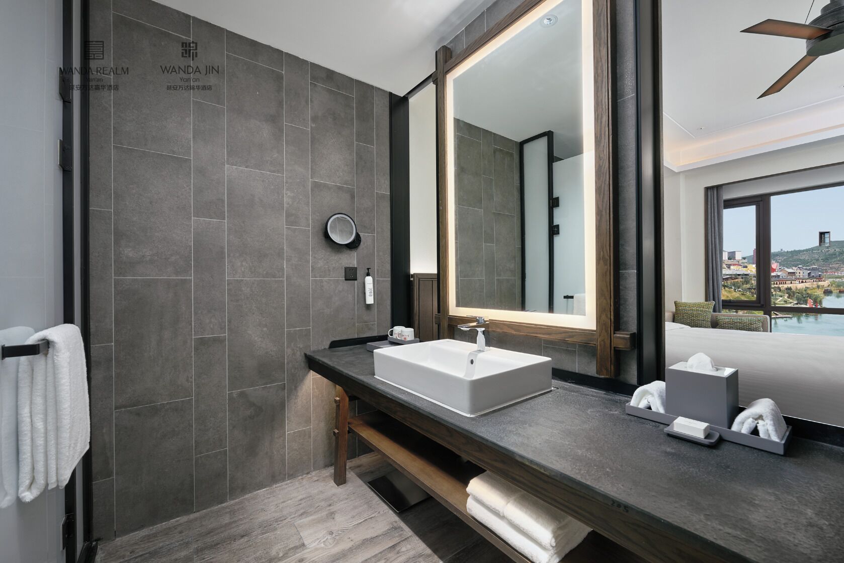 Ein modernes Badezimmer mit großem Spiegel, weißem Waschbecken und Handtuchhalter.