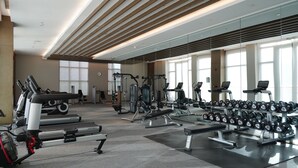 A modern gym with cardio machines, free weights, and a mirrored wall. - WANDA JIN Yan'an (Yan'an)