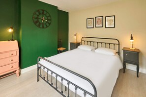 A bedroom with a bed, a dresser, a nightstand, a clock, and three framed pictures on the wall. - Host Stay Blatchington Road (Hove)