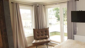 Une chambre à coucher avec un lit, une chaise et un téléviseur.