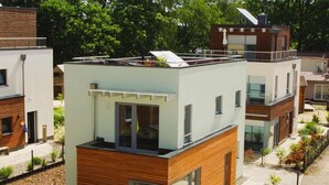 Un bâtiment moderne à deux étages, doté d’un toit plat, de grandes fenêtres et d’une façade en bois.