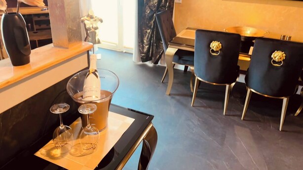 A dining area with a table set for two, featuring a bottle of wine and two wine glasses. - Weißt Du Noch- Luxus am See (Krakow am See)