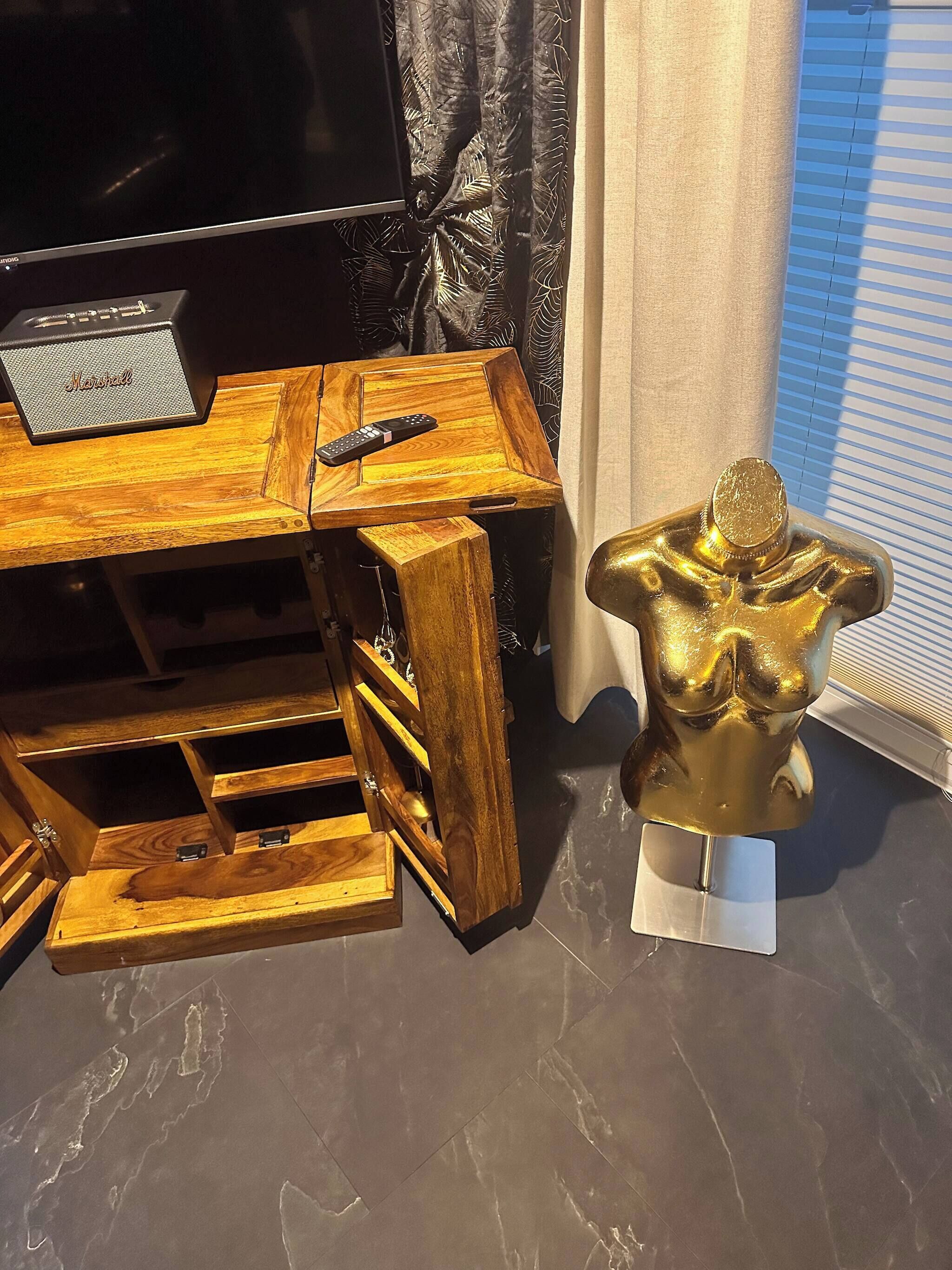 A wooden entertainment center with a TV, a speaker, and a remote control.