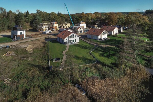 An aerial view of a residential area with houses, a construction crane, and a clear sky. - Wing King Elegance & Nature (Krakow am See)