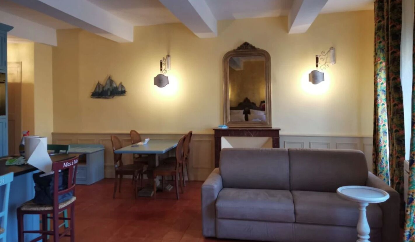 Un coin repas avec une table et des chaises, un canapé et un miroir au mur.