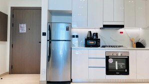 Una cocina moderna con un refrigerador de acero inoxidable, un microondas, un horno empotrado y una estufa a gas.
