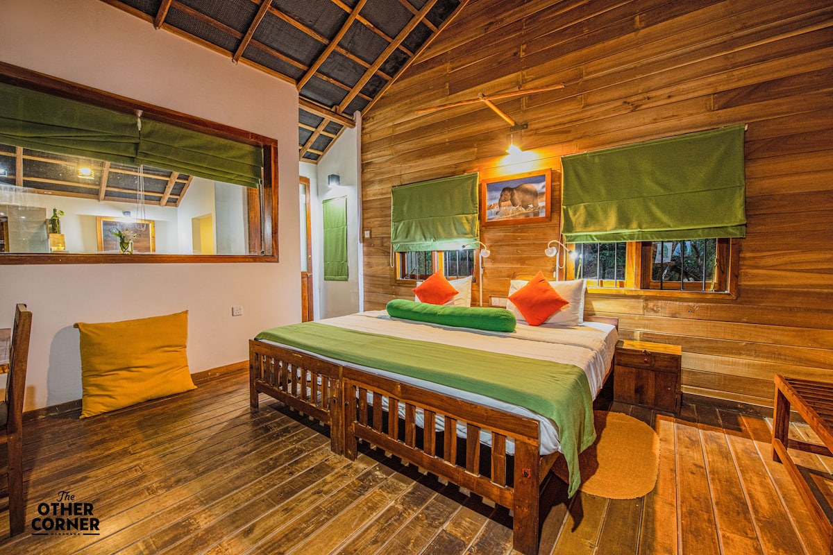 Un dormitorio de estilo cabaña de madera con cama, almohadas y mesita de noche.