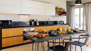 Een moderne keuken met houten kastjes, een zwart aanrecht en een ontbijtbalk.